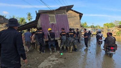Bahu Membahu, Brimob Pindahkan Rumah Terseret Banjir yang Melintang di Jalan Nasional Tamiang–Langsa